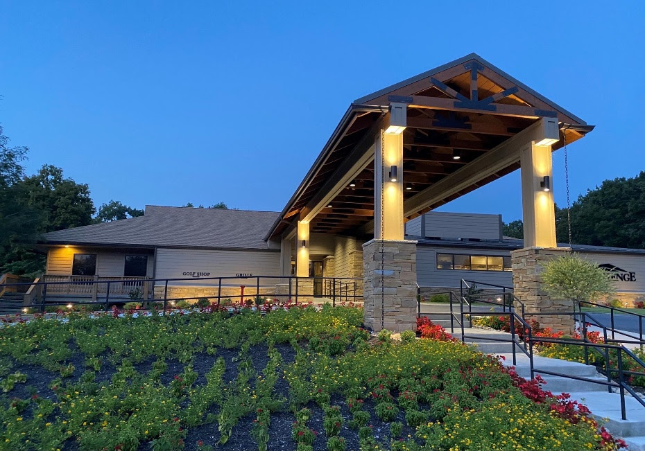 A building with a covered porch and a garden

Description automatically generated